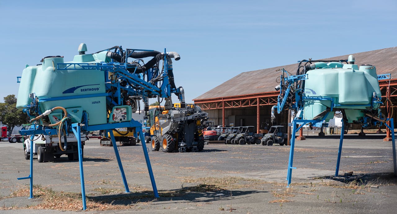 Agricultural machinery displayed in a rural outdoor scene with clear sky.